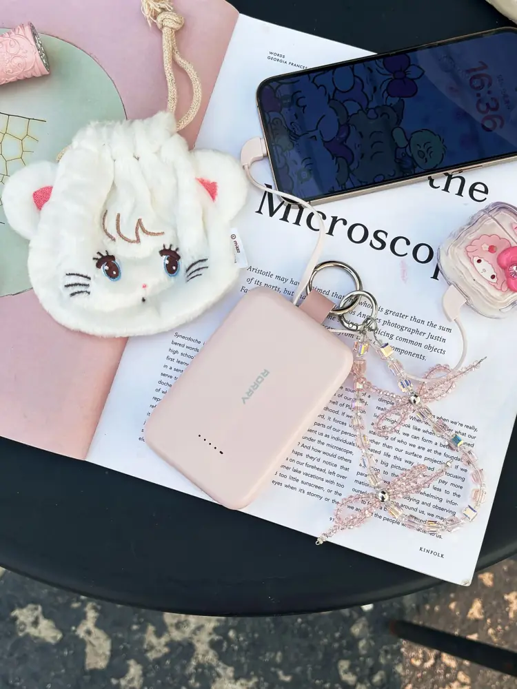 White kitty plush pouch with a phone and pink power bank