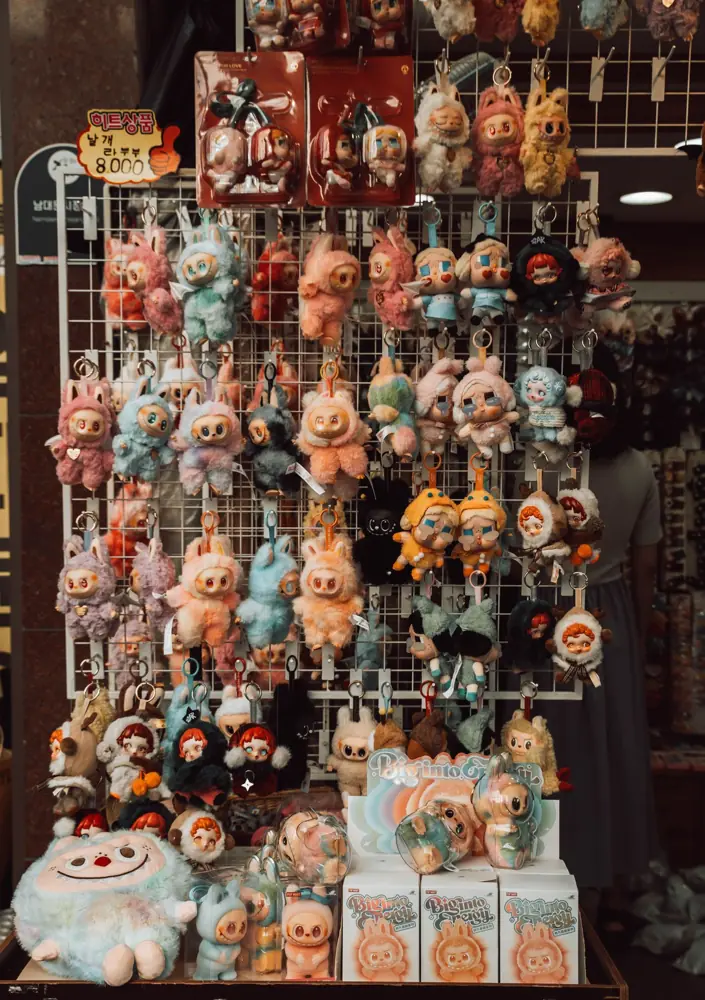 Rows of small plush keychains hanging on a display