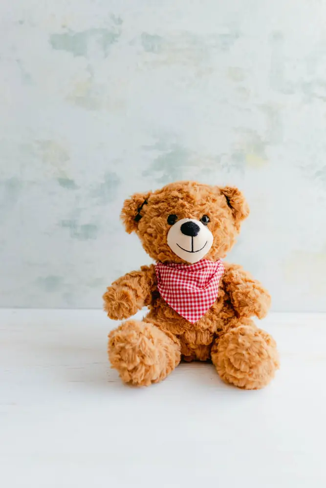 Brown teddy bear with a pink gingham bandana